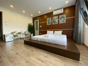 a bedroom with a large bed and a table at Homestay Tự Do in Hue +20 photos