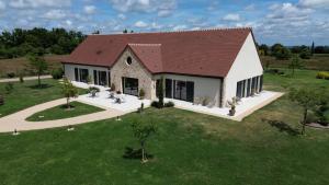 een uitzicht op een groot huis met een tuin bij Aux 3 Forêts in Bizeneuille