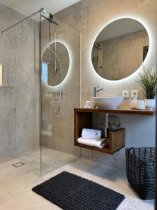 コマルナにあるChic apartment for a relaxing holiday in Komarnaのバスルーム(洗面台、鏡2つ付きのシャワー付) +1枚の写真