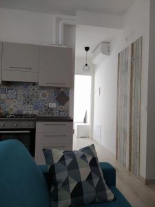 a living room with a blue couch and a kitchen at A casa di Azzurra in Roseto degli Abruzzi