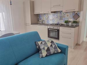 a living room with a blue couch and a kitchen at A casa di Azzurra in Roseto degli Abruzzi