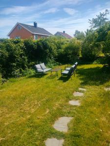 two park benches and a table in a field at Romslig leilighet på Træleborg i Tønsberg in Tønsberg