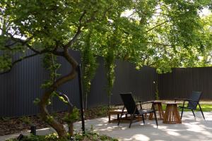 a patio with a table and chairs under a tree at Hotel Node in Swarzędz