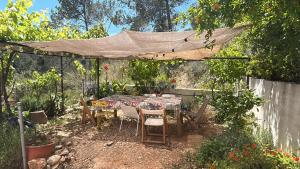 a table and chairs under a canopy in a garden at Son Roca Ribes Guest House in Sant Pere de Ribes