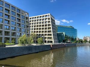 Boulevard Drobnera IV - Apartament nad Odrą - Rynek في فروتسواف: مبنيين شاهقين بجوار نهر مع المباني