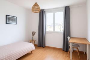 a bedroom with a bed and a desk and a window at Appartement spacieux de 92m2 in Brest