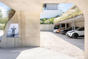 a building with cars parked in a parking lot at Duinhotel Tien Torens in Zoutelande