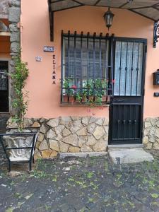 a pink house with a black door and a bench at Casa Eliana in Marino