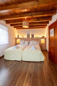 a large white bed in a room with wooden ceilings at La Olivia 53 Boutique con zona Chill Out A 5 min de Cangas de Onís in Cangas de Onís