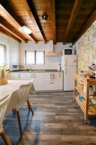 a kitchen with a table and a refrigerator at La Olivia 53 boutique con zona chill out exterior in Cangas de Onís