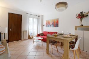 a living room with a table and a red couch at Villino Flora a Viareggio in Viareggio