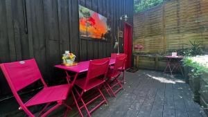 un grupo de mesas y sillas rosas en un patio en LeLoft au dessus des Pins, en Lacanau