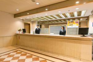 um lobby com dois homens de pé em um balcão em Gifu Washington Hotel Plaza em Gifu