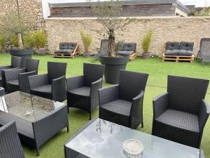 a patio with chairs and tables on a lawn at Loft & Spa LE FAUBOURG SAINT MARTIN in Senlis