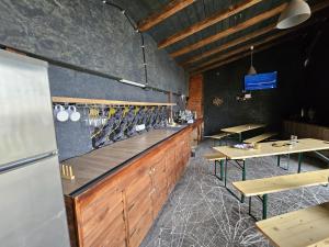 a restaurant with a bar with wooden counters and tables at One & Kos Resort in Costinesti
