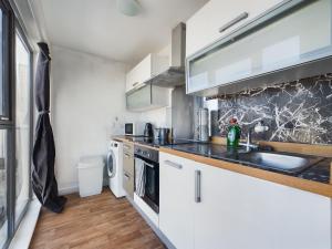 Una cocina con gabinetes blancos y un fregadero. en Stylish Central Apartment 2 Beds 4 Guests, en Liverpool