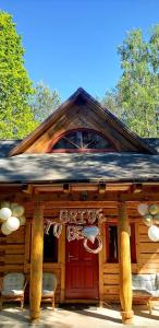 a log cabin with a red door and two chairs at Góralska chata in Smardzewice +8 photos