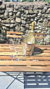 a basket with a bottle of wine and two glasses on a table at Fig Tree Cottage in North Cornelly