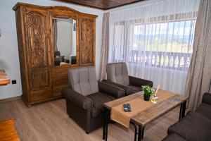 a living room with a couch and two chairs and a table at Къща Джано in Dobrinishte