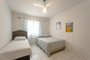 a bedroom with two beds and a window at Apartamento Econômico - AL09 in Maringá