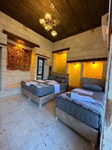 a room with three beds in a stone walled room at Sular konağı butik otel in Sanlıurfa