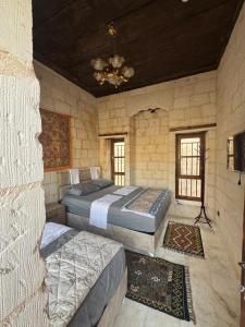 a bedroom with two beds in a stone wall at Sular konağı butik otel in Sanlıurfa
