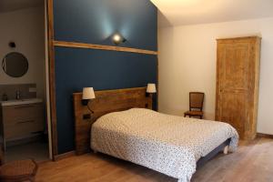 a bedroom with a bed and a blue wall at La Bauderie in Bussières +42 photos