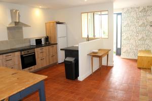 a kitchen with a refrigerator and a table in it at La Bauderie in Bussières
