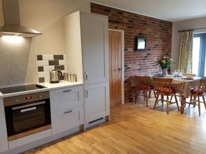 eine Küche mit weißen Schränken und einem Tisch mit Stühlen in der Unterkunft Beech Cottage in Boston