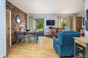 ein Wohnzimmer mit einem blauen Sofa und einem Esszimmer in der Unterkunft Beech Cottage in Boston