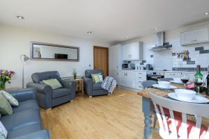 ein Wohnzimmer mit Tisch und Stühlen und eine Küche in der Unterkunft Ash Cottage in Boston