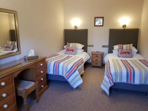une chambre d'hôtel avec deux lits et un miroir dans l'établissement Oak Cottage, à Boston