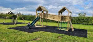 un enfant sur une balançoire dans un parc dans l'établissement Elm Cottage, à Boston