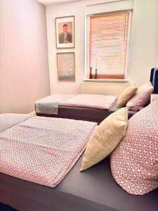 a room with three beds with pillows and a window at Haus Gitta - Wohlfühlen & Genießen in Luckenwalde