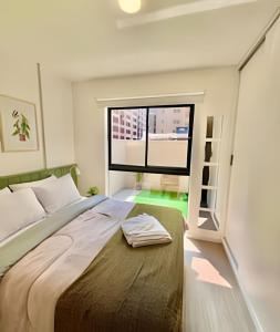 a bedroom with a bed and a large window at GaRDEN, Espetacular Apto com ar Condicionado in Curitiba