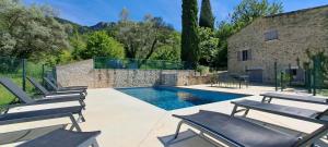 a group of chairs sitting next to a swimming pool at Le Mas des Fontettes, gite 14 personnes, piscine chauffée, propriété 5ha, barbecue in Sahune