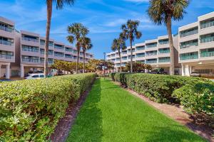 a hedge lined path in front of a building at Casa Del Mar - Mi Casa 113 in Galveston