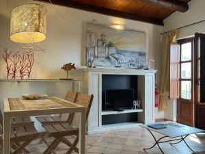 Una sala de estar con una mesa y una chimenea. en Il Mulino, en Cefalú