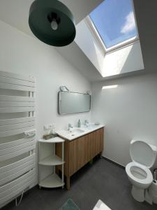 Un baño con lavabo, espejo e inodoro. en La Grange maen, en Pont-Saint-Martin