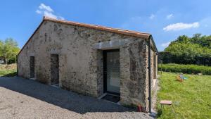 un antiguo edificio de piedra con una puerta grande en La Grange maen, en Pont-Saint-Martin