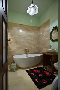 a bathroom with a white tub and a sink and a mirror at Pensiunea Tihna in Rîu de Mori