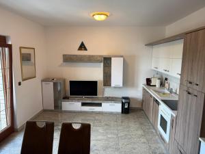 a kitchen with white cabinets and a tv in it at Villa Kopic in Opatija