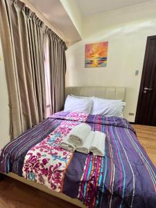 a bedroom with a bed with towels on it at Bayview near CCP, PICC, Airport, MOA, Okada at Radiance in Manila