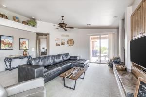 a living room with a leather couch and a tv at Santa Clara Sunrise in Santa Clara