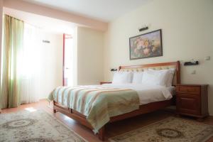 a bedroom with a large bed and a window at Hotel Nemira in Slănic-Moldova