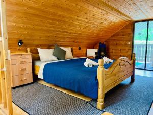 a bedroom with a bed in a wooden room at Countryside riverside cabin for both winter and summer in Janakkala