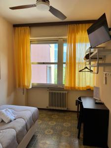 a bedroom with a bed and a window with yellow curtains at Hotel Diana in Riva del Garda
