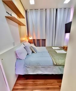 a small bedroom with a bed and a window at O Studio ACONChEGO bem no centro de Curitiba in Curitiba