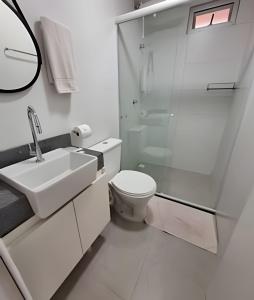 a white bathroom with a toilet and a shower at Estúdio Elegante, bem no centro - Ar quente/frio in Curitiba