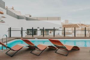 two chairs and a swimming pool on a balcony at Vincci Selección Posada del Patio in Málaga